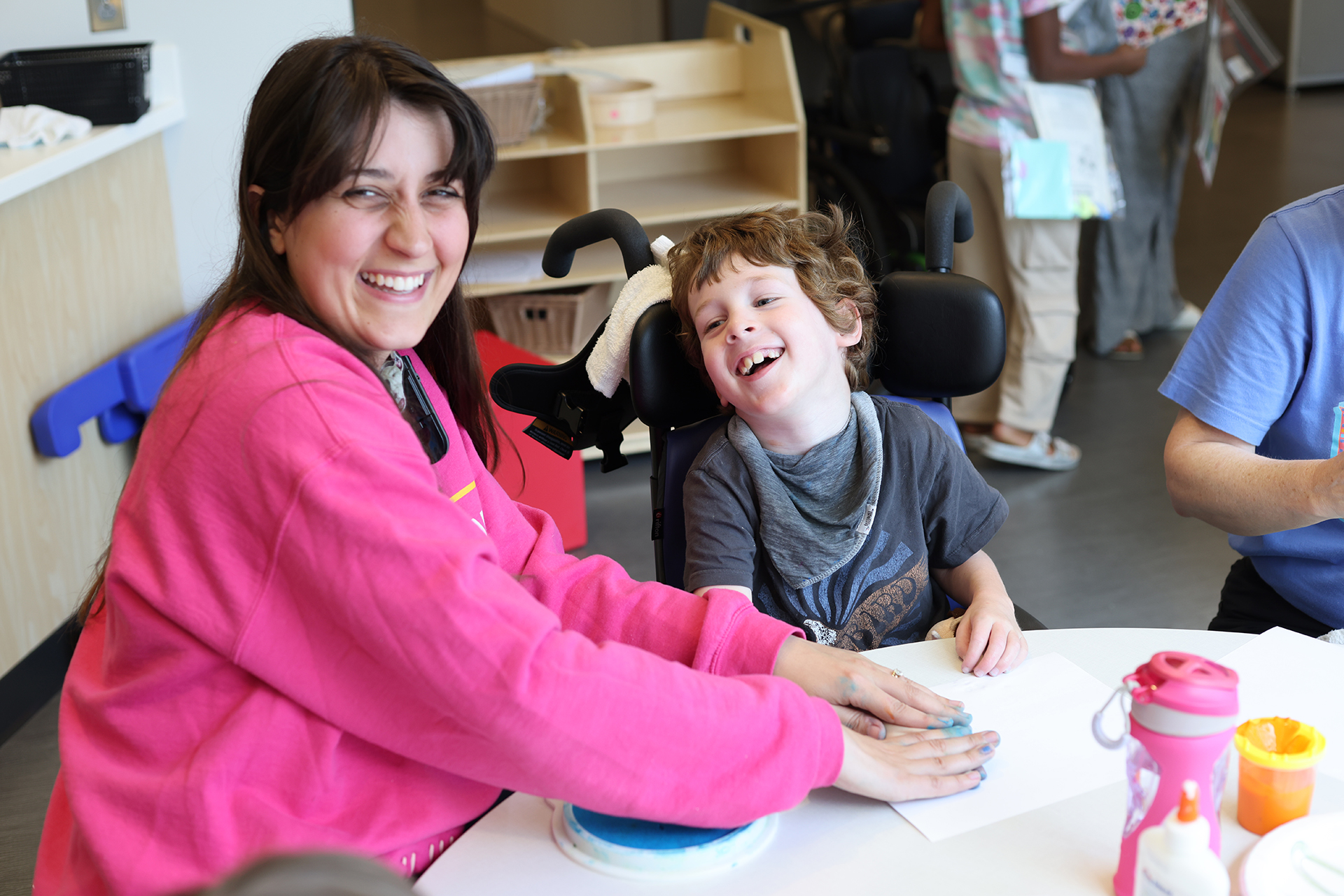 Female therapist with a male Ranken Jordan patient during an outpatient camp session